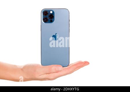 Bratislava, Slovacchia - 07 dicembre 2020. Mano femminile che presenta il nuovo iPhone 12 Pro Max Pacific Blue isolato su sfondo bianco. Foto Stock