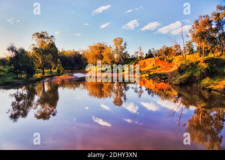 Pigro fiume macquarie che scorre in pianura Great Western attraverso Dubbo città paese agricolo dell'Australia in una calda estate giorno di sole - outback rosso Foto Stock