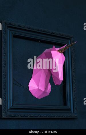 Viola mock-up origami unicorno fatti a mano in testa in una cornice blu da una foto di una parete blu Foto Stock