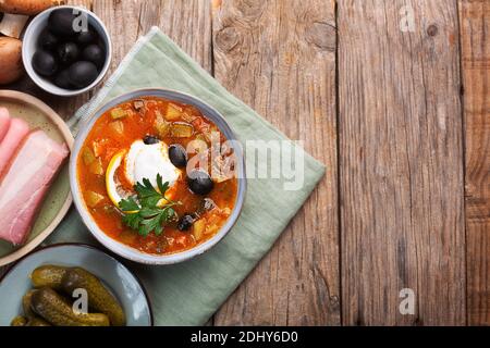 Solyanka, zuppa russa con salsiccia, olive, cetriolo e capperi. Vista dall'alto con spazio per la copia Foto Stock