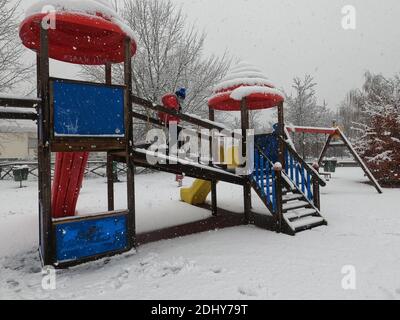 Mortara - 12-04-2020: Bambini che giocano nel parco giochi sotto la neve nel nord Italia Foto Stock