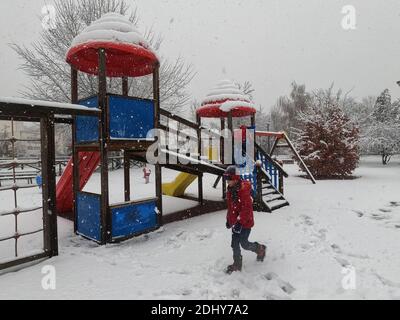 Mortara - 12-04-2020: Bambini che giocano nel parco giochi sotto la neve nel nord Italia Foto Stock