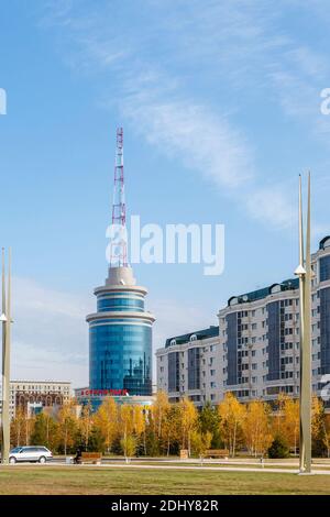Moderno edificio rotondo rivestito di vetro blu riflettente con palo trasmettitore di comunicazione nel centro di Nur-Sultan (Astana), capitale del Kazakhstan Foto Stock