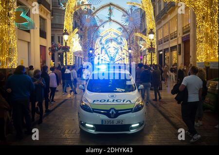 Una polizia locale auto è visto pattugliare lungo la via Marques de Larios durante la stagione di Natale. Dopo i nuovi cambiamenti delle restrizioni annunciate dal governo andaluso, la polizia nazionale spagnola, La polizia locale di Malaga e i membri della protezione civile controlleranno le folle nel centro della città durante la stagione natalizia con barriere e controlli di polizia nelle strade principali di Malaga. Foto Stock