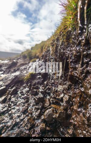 Dettaglio di fangoso sentiero escursionistico con acqua di gocciolamento a scottish isola di skye Foto Stock