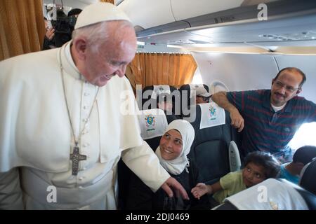 Papa Francesco saluta i rifugiati siriani Osama (36) sua moglie Wafaa (29) e i loro figli Masaa (8) e Omar (6) durante il volo da Lesbos all'aeroporto di Roma Ciampino (Italia) il 16 aprile 2016. Papa Francesco riportò 12 rifugiati siriani a Roma dopo una breve visita all'isola greca di Lesbo. Tutte e tre le famiglie hanno visto le loro case bombardate in Siria e tutte e tre sono arrivate in Grecia dalla Turchia su barche di gomma sovraccaricate. Ora, le famiglie stanno iniziando un nuovo viaggio: Lezioni di lingua e integrazione in una nuova cultura. Osama ha detto che alle 10 aprile 15 gli è stato detto che lui, sua moglie e i suoi figli Omar, Foto Stock