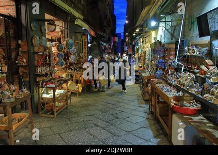 Napoli, 12 dicembre 2020 : Via San Gregorio Armeno, famosa in tutto il mondo per le sue botteghe artigiane per la costruzione di presepi napoletani e pastori tradizionali che attraggono turisti da tutto il mondo. In questo periodo di restrizioni d'emergenza da Covid-19, gli artigiani tentano di vendere i loro prodotti artigianali ai pochi turisti che viaggiano in questo modo.fino all'anno scorso è stato affollato di visitatori, Ma quest'anno notiamo la scarsità di presenze a causa delle limitazioni al movimento tra i comuni imposti dal governo italiano per affrontare la diffusione del virus.UN artigiano lavora nel suo Foto Stock