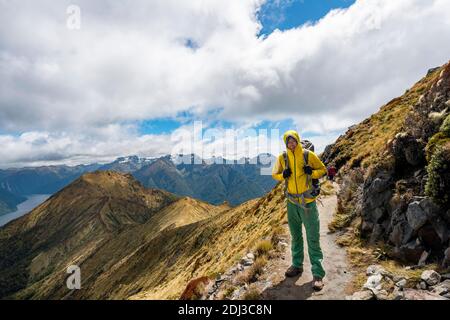 Escursionista su Kepler Track, Great Walk, vista del fiordo sud del lago te Anau, Murchison Mountains sullo sfondo, Fiordland National Park Foto Stock