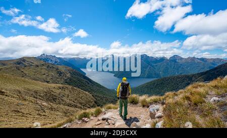 Escursionista su Kepler Track, Great Walk, vista del fiordo sud del lago te Anau, Murchison Mountains sullo sfondo, Fiordland National Park Foto Stock