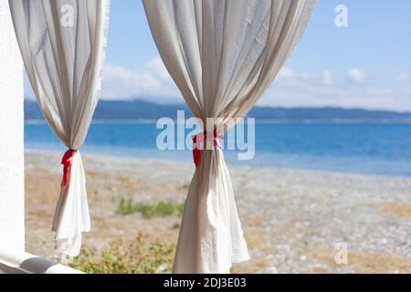 Tende bianche contro il mare Foto Stock