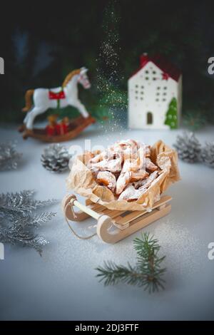 Legna da ardere con zucchero. Biscotti croccanti a forma di iciclette su una slitta giocattolo in una composizione natalizia. Biglietto d'auguri di Natale . Foto Stock