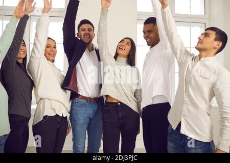 Felice giovane business team multirazziale che acclamano e festeggiano il successo professionale Foto Stock