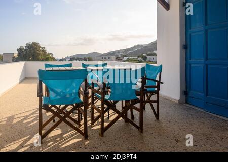 IOS, Grecia - 20 settembre 2020: Sedie con tavoli sul balcone della villa greca estiva sull'isola di iOS. Grecia Foto Stock