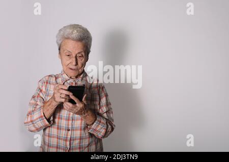 Donna anziana che usa il suo smartphone. Social networking. Smartphone. Foto Stock