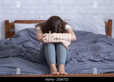 Giovane donna stressata con emozioni negative, sentendosi depresso e piangendo a letto Foto Stock