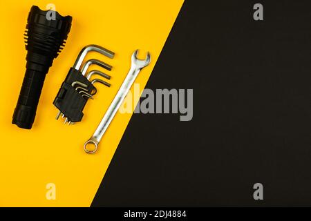 Set di strumenti, torcia e chiavi su un semplice sfondo piatto, copia foto spazio Foto Stock