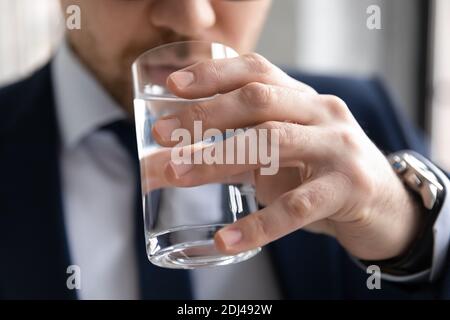 Primo piano uomo d'affari sicuro che beve acqua minerale pura fresca Foto Stock