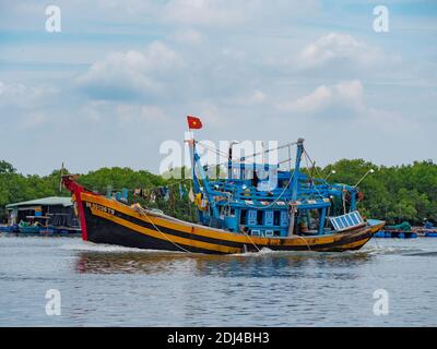 Barca da pesca che scende lungo il fiume Dinh vicino a Vung Tau nella provincia di Bang Ria-Vung Tau del Vietnam del Sud. Foto Stock