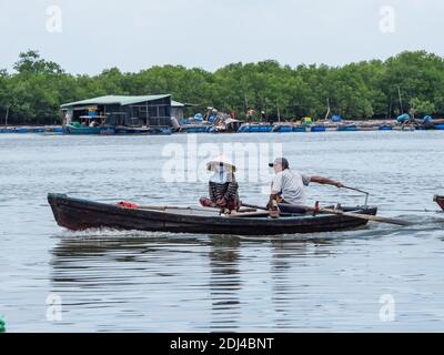 Piccolo motoscafo con due persone che scende lungo il fiume Dinh vicino a Vung Tau nella provincia di Bang Ria-Vung Tau del Vietnam del Sud. Foto Stock