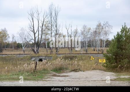 Pipyat, area di esclusione di Chernobyl, Ucraina - segnali di pericolo vicino alla Foresta Rossa, un sito ad alta radioattività nella zona di esclusione di Chernobyl vicino al fantasma Foto Stock