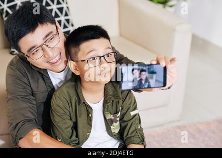 Padre e figlio che prendono selfie Foto Stock