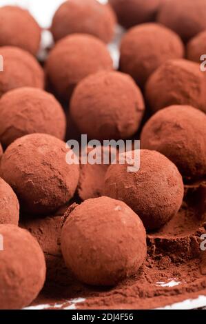 Tartufi di cioccolato con cacao in polvere su fondo bianco Foto Stock