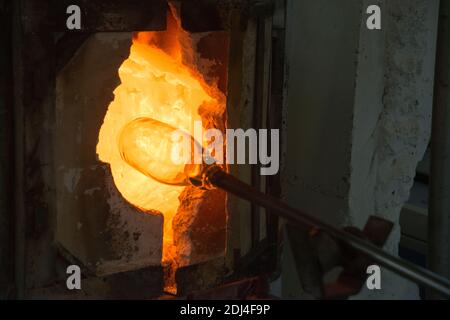 Vetraio officina del vetro è nel forno per la fusione prima della formazione Foto Stock