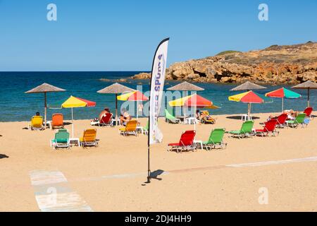 Lettini e ombrelloni presso la spiaggia di Iguana (spiaggia di Agii Apostoli), la Canea, Creta, Grecia Foto Stock