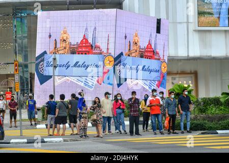 Kuala Lumpur, Malesia. 13 Dicembre 2020. Le persone che indossano maschere facciali aspettano di attraversare una strada a Kuala Lumpur, Malesia, 13 dicembre 2020. Credit: Chong Voon Chung/Xinhua/Alamy Live News Foto Stock