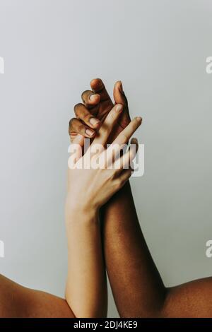 Armi di donne bianche e nere, concetti di integrazione razziale, uguaglianza sociale dei diritti umani Foto Stock