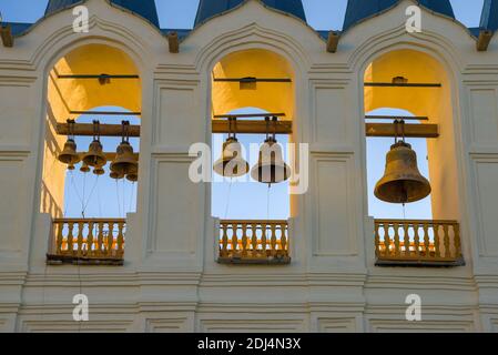 Campane sul vecchio campanile del monastero dell'Assunzione di Tikhvin Theotokos alla luce della sera. Regione di Leningrad, Russia Foto Stock