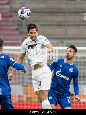 Augusta, Germania. 13 Dicembre 2020. Calcio: Bundesliga, FC Augusta - FC Schalke 04, 11° incontro nella WWK-Arena. Rani Khedira (l) di Augusta e Mark uth di Schalke sono in un duello di testata. Credito: Stefan Puchner/dpa - NOTA IMPORTANTE: In conformità con le norme del DFL Deutsche Fußball Liga e del DFB Deutscher Fußball-Bund, è vietato sfruttare o sfruttare nello stadio e/o nel gioco le fotografie scattate sotto forma di sequenze di immagini e/o serie di foto di tipo video./dpa/Alamy Live News Foto Stock