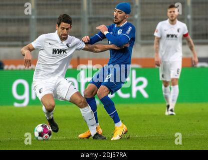 Augusta, Germania. 13 Dicembre 2020. Calcio: Bundesliga, FC Augusta - FC Schalke 04, 11° incontro nella WWK-Arena. Rani Khedira (l) di Augusta e Omar Mascarell di Schalke combattono per la palla. Credito: Stefan Puchner/dpa - NOTA IMPORTANTE: In conformità con le norme del DFL Deutsche Fußball Liga e del DFB Deutscher Fußball-Bund, è vietato sfruttare o sfruttare nello stadio e/o nel gioco le fotografie scattate sotto forma di sequenze di immagini e/o serie di foto di tipo video./dpa/Alamy Live News Foto Stock