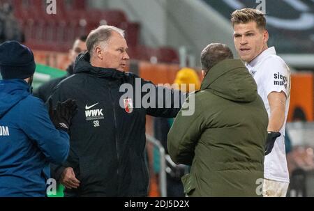 Augusta, Germania. 13 Dicembre 2020. Calcio: Bundesliga, FC Augusta - FC Schalke 04, 11° incontro nella WWK-Arena. Il direttore sportivo Stefan Reuter (Augusta, l) opera tra il coach Manuel Baum (Schalke, M) e Florian Niederlechner . Credito: Stefan Puchner/dpa - NOTA IMPORTANTE: In conformità con le norme del DFL Deutsche Fußball Liga e del DFB Deutscher Fußball-Bund, è vietato sfruttare o sfruttare nello stadio e/o nel gioco le fotografie scattate sotto forma di sequenze di immagini e/o serie di foto di tipo video./dpa/Alamy Live News Foto Stock