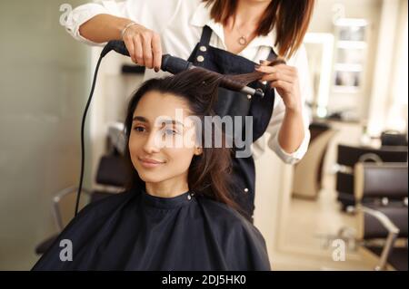 Parrucchiere riccia i capelli della donna, parrucchiere Foto Stock