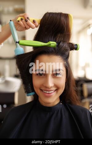 Parrucchiere ricci i capelli della donna, vista closeup Foto Stock