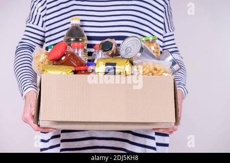 I volontari raccolgono i prodotti alimentari nella scatola di donazione e nella custodia Foglio di carta con messaggio grazie Foto Stock