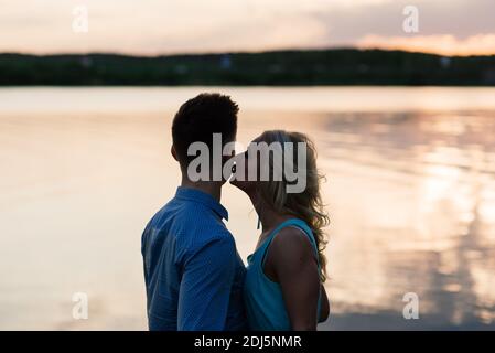 Silouette, coppia amorevole sul lago durante il tramonto Foto Stock