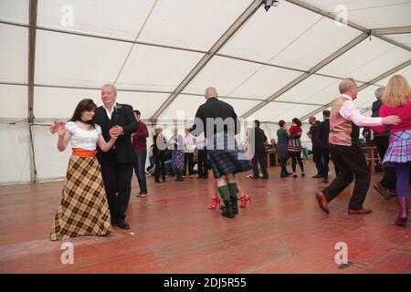 Brucia un che, Celidh a Rozelle PRK, Ayr, Ayrshire Scozia. James (Jim ) primo giocatore di tastiera con Diacono Blu danzare con signora in lungo abito tartan Foto Stock