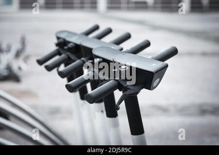 La fila di scooter elettrici in affitto sulla strada della città. Scooter elettrici per la condivisione pubblica. Servizio di noleggio di mezzi di trasporto self-service Foto Stock