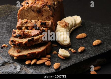 Pane di banana su fondo di pietra scura. Con mandorle e noce Foto Stock