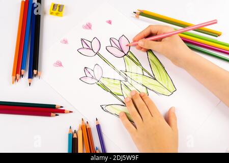 Bambina disegna fiori su un foglio bianco. Foto Stock