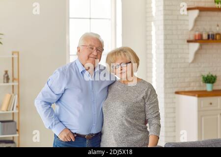 Ritratto di una coppia anziana amorevole che si abbracciano in piedi in cucina a casa. Foto Stock