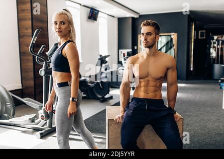 Giovane coppia sportiva, donna e muscolosa, in palestra Foto Stock