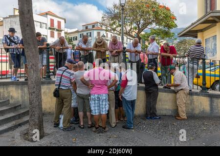 Gruppo di uomo anziano che guarda a due carte da gioco uomo Foto Stock