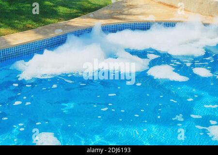 Acqua blu della piscina e schiuma lasciata dalla festa Foto Stock