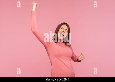 Estremamente felice donna soddisfatta mostrando sì gesto e urlando celebrando la sua vittoria, successo, sogni diventa vero, euforia. Studio interno girato è Foto Stock