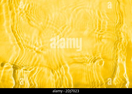 Astratto sfondo giallo di onde e increspature sull'acqua. Foto Stock