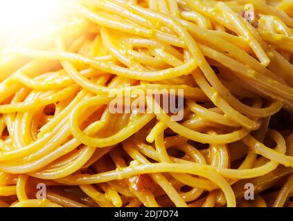 Vista ravvicinata degli spaghetti con salsa di carbonara. Ricetta romana tipica con uova, pancetta, pecorino romano e parmigiano. Cucina e ricette tipiche italiane Foto Stock