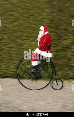 Padre Natale a cavallo di una bicicletta Penny Farthing Foto Stock